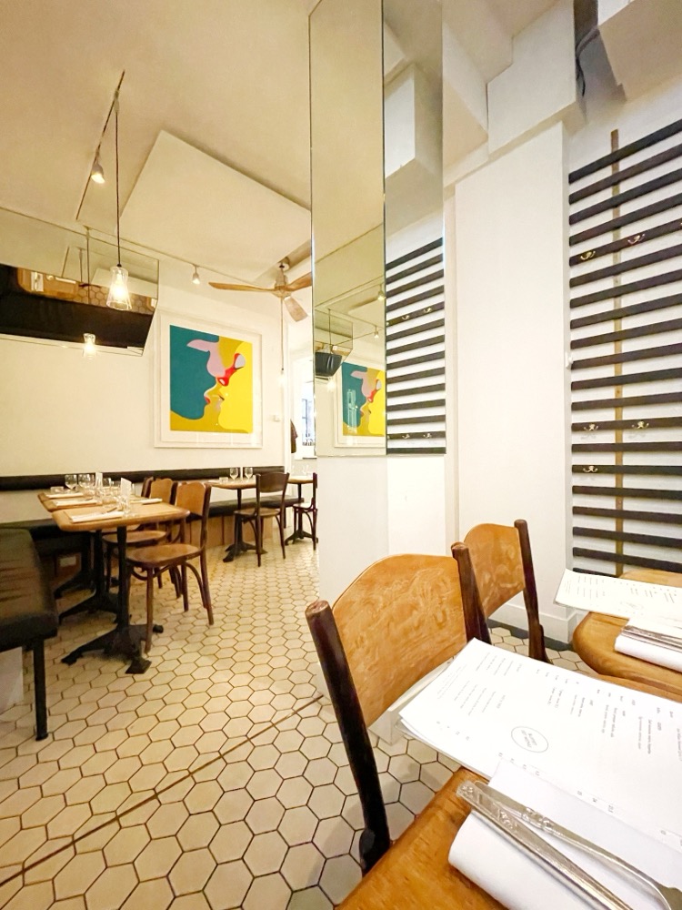 Sitting in the back of a hip-looking restaurant; light walls, colourful wall art