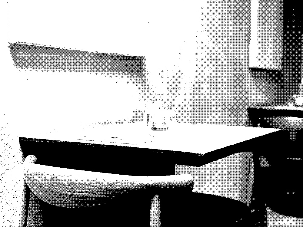 A two-person gray table with wood finish at a ramen restaurant waits for guests